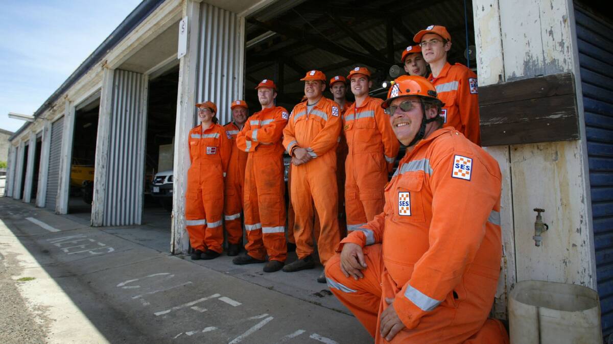 Warrnambool SES volunteer Daryl Hose (front) with other members outside their dilapidated Nicholson Street shed which has an asbestos roof, leaks and faults in the electrical wiring.