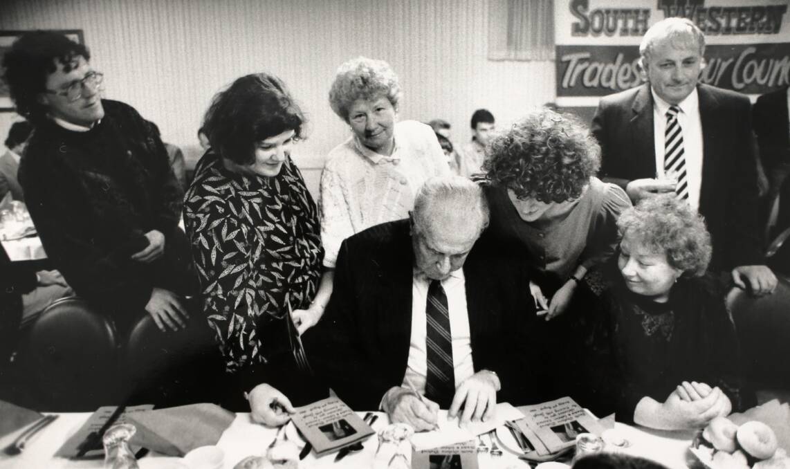Gough Whitlam signs copies of his book for supporters at the Richmond Henty Hotel, Portland, in August 1990. Picture: Simon O'Dwyer,.