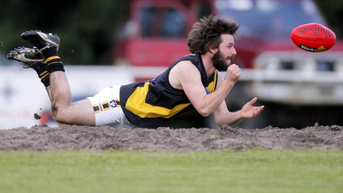 Woorndoo-Mortlake's John Hooper throws out a desperate handpass. Picture: ROB GUNSTONE