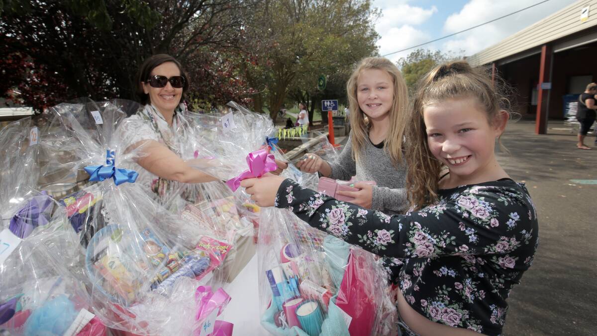 School mum Jenny Place at the 'fill a basket' stall with Lili-Jayne Morey, 12, and Ella O'Brien, 12, both from Warrnambool. 