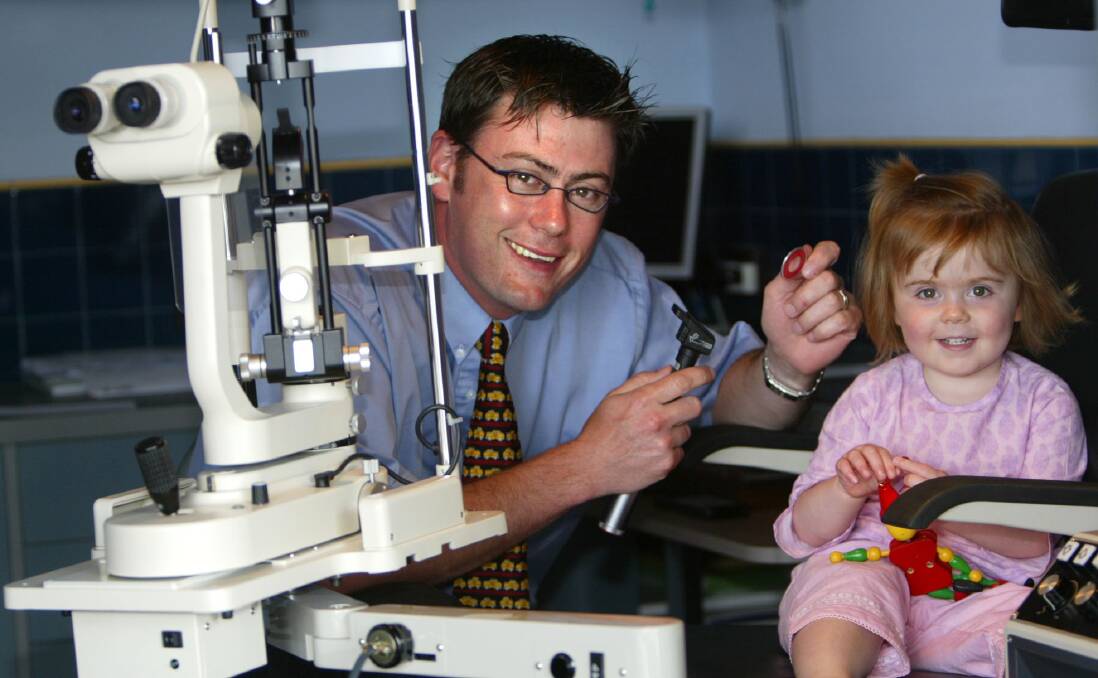 Optometrist Simon Routson checks two-year-old Ella's eyesight.
