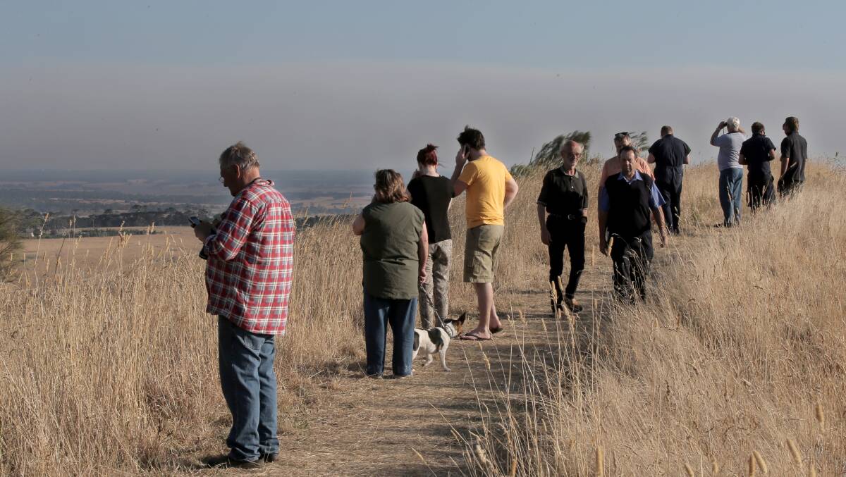 Local residents watch from the top of Mount Leura in Camperdown, as smoke rises from the Stoneyford fire.