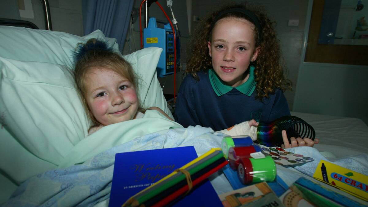 Letitia Townsend, 4, in bed with a broken arm with Alice McLaren, 12, from West Warrnambool Primary School. They have donated toys to the children in the childrens ward at Southwest Health Care.