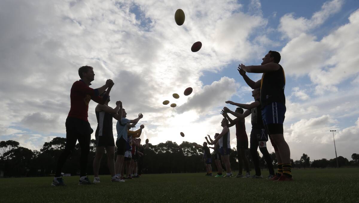Deakin players warm up in the twilight at the Pond. Picture: AARON SAWALL