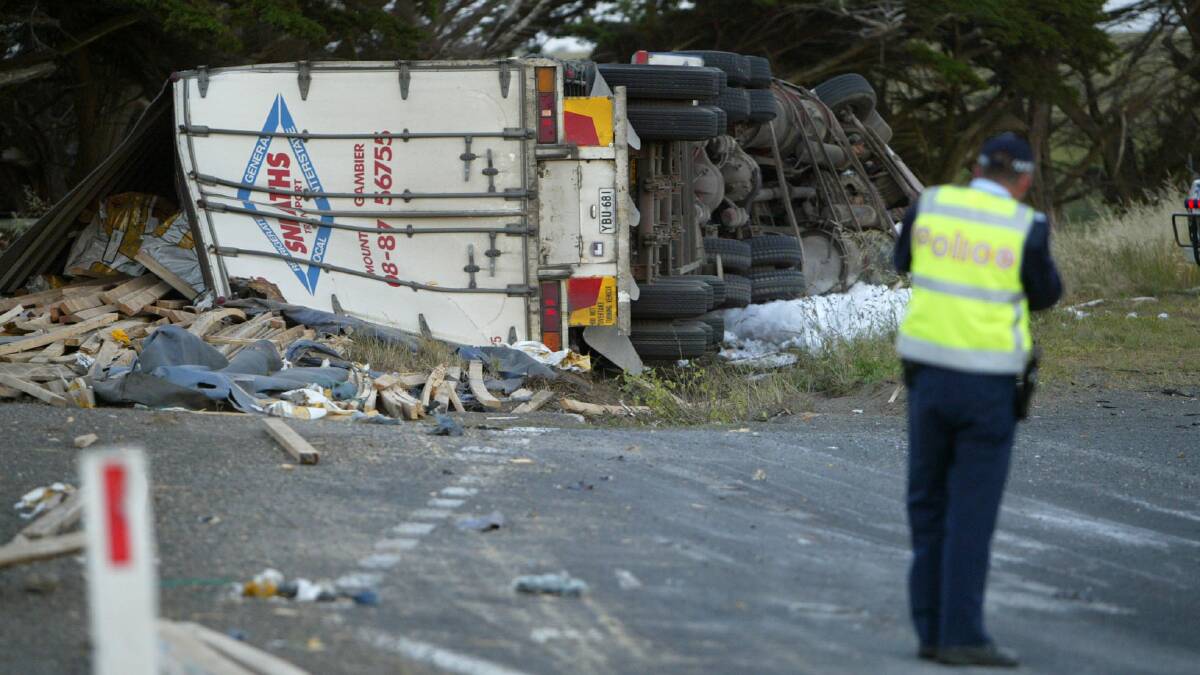A Mount Gambier man died in a crash near Port Fairy - pictured is his truck's load of pine timber scattered on the road.