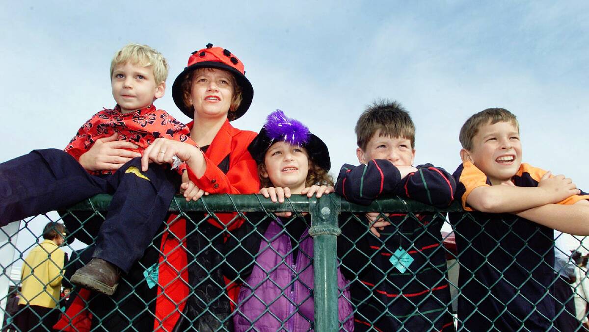 Felicity Clancey with son Hugh, 4, daughter, Prue, 6, family friend Nick Dillon, 9, and Tom Clancey, 8, watching the racing action from over the members fence in 2001.