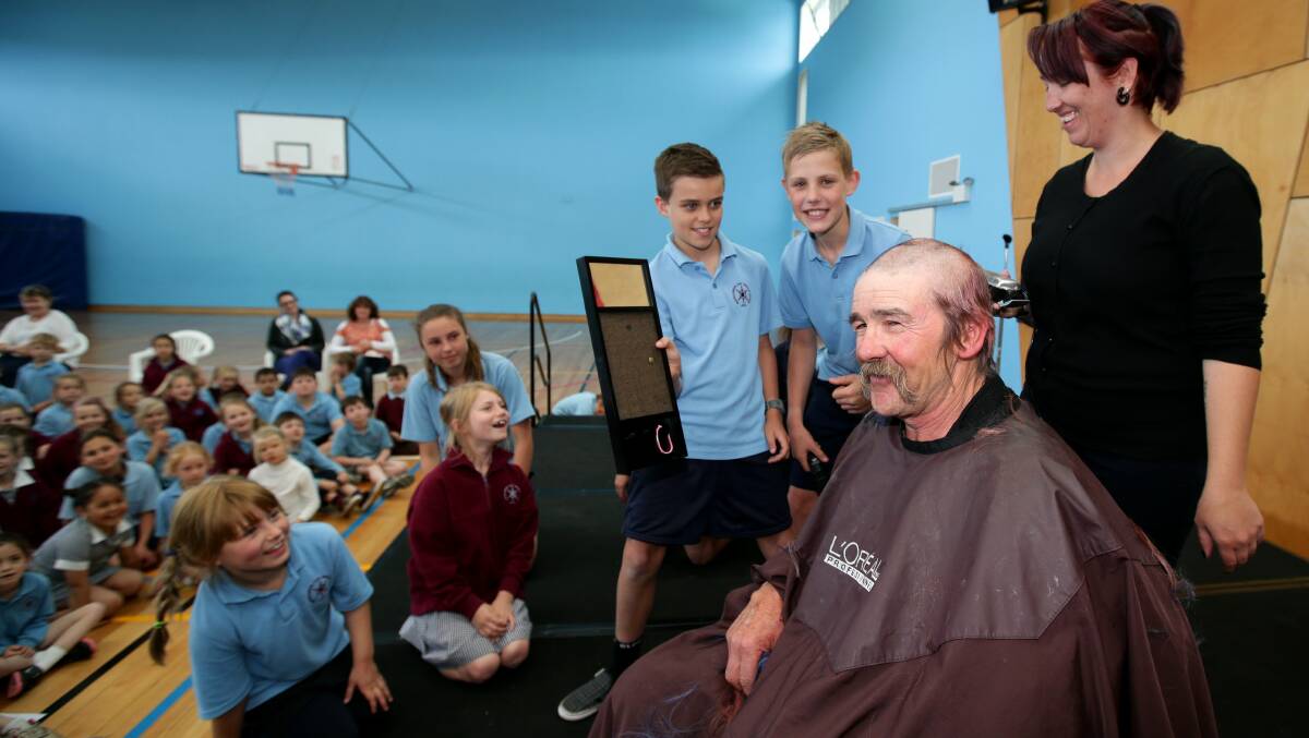 Jimmy Boxer says goodbye to his hair, with staff and students looking on.
