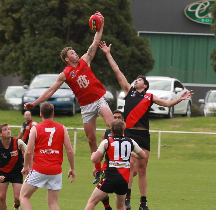 LEAP: Dogs ruckman Justin Wallace gets the tap out against East Warrnambool.