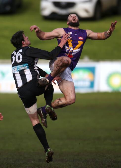 FLYING HIGH: Port Fairy ruckman Adam McCosh leaps over Camperdown's Will Rowbottom at a ball-up on Saturday. Picture: Amy Paton