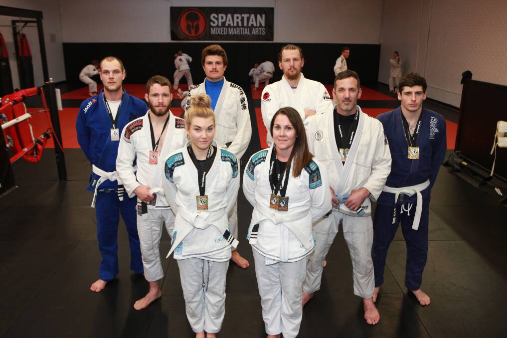 SPARTAN SUCCESS: Spartan MMA members (left to right) Chris Smith, Lachlan Dartm, Alish Smith, Jackson Fary, Melanie Mason, coach Tra-ill Dowie, David Gibb and Sam McCarthy. Picture: Susie Giese