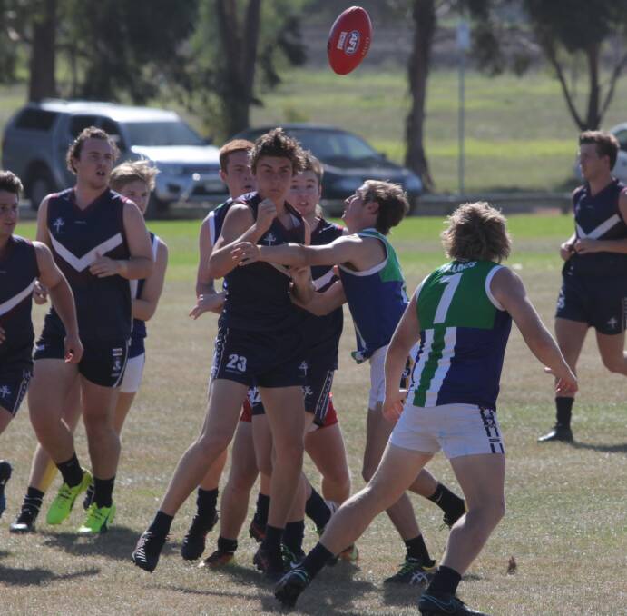UNDER PRESSURE: Emmanuel College student Harry Donnelly gets a handball away as Warrnambool College students close in. Picture: Susie Giese