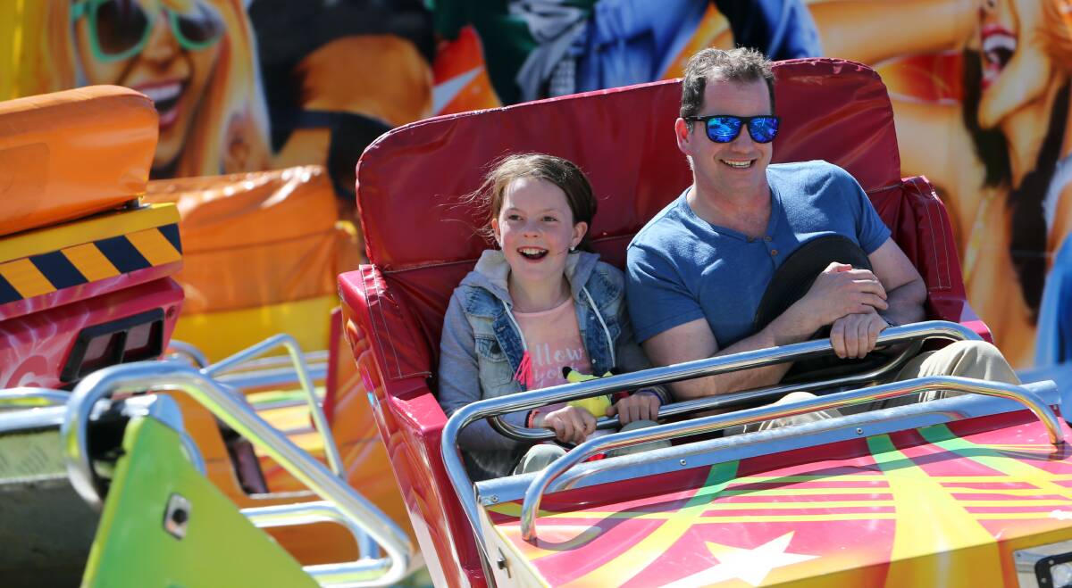 HOLD ON: Tayla Roberts from Killarney enjoys a ride at the Warrnambool Show with her dad Jason.  Picture: Rob Gunstone