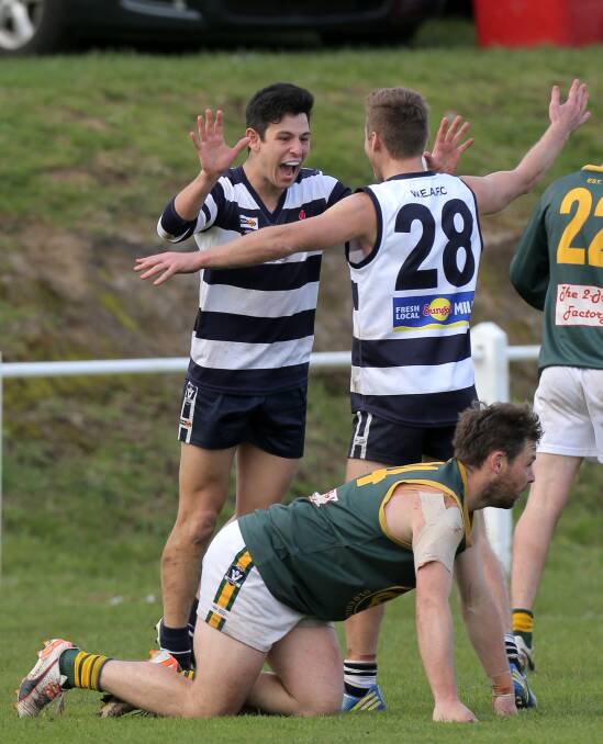 IT'S OURS: Allansford's Josh Brown celebrates with teammate Jeremy Parkinson late in the last quarter on Sunday. Old Collegians defender Aaron Williams is left to ponder the end of the Warriors season. Picture: Rob Gunstone
