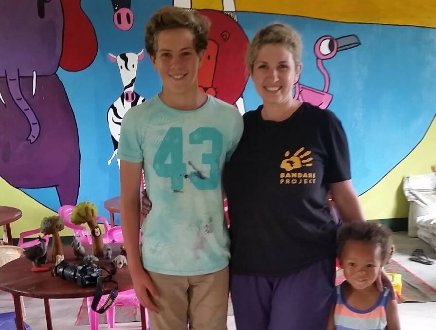 VOLUNTEERS: Port Fairy's Reuben and Sheree Duncan and a grateful local in front of the mural they helped create as part of their journey to Tanzania. Taking part in the project was a memorable experince for the mother and son. 