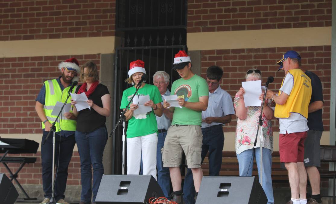 SING ALONG: The Koroit Lions Club get into the spirit of the day with a rendition of their favourite carol on Sunday at the Koroit Railway Station. 