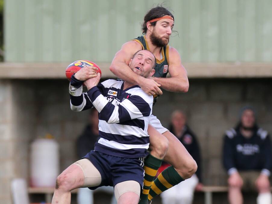 BODY ON THE LINE: Allansford's Travis Membrey completes the mark despite pressure from Old Collegians' Jacob Dunkley.  Picture: Rob Gunstone
