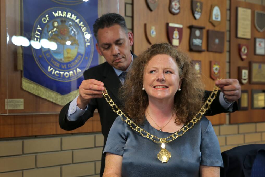 Mayor Kylie Gaston receives the mayoral chain from outgoing mayor Michael Neoh. Picture: Rob Gunstone