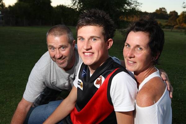 Jackson Merrett shares the moment with parents Greg and Cathy at the family’s Cobden home after last night’s AFL draft.
