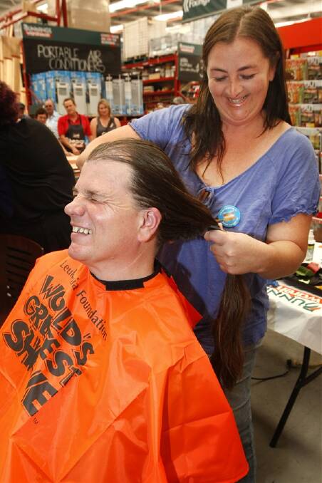 Michael Medwin grimaces as Tina Wise starts the hair cut.