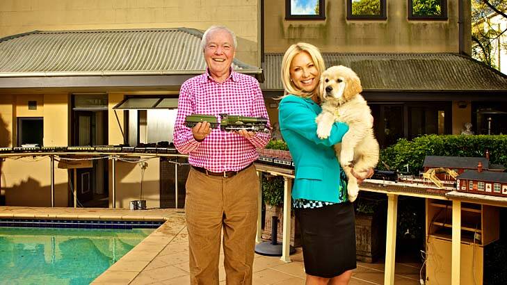Kerri-Anne Kennerley her husband John at her Woollahra home with his model train set and their puppy, Digger. Photo: Marco Del Grande