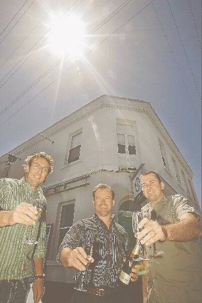 Rodger Construction staff (from left) Sam Stevens, Jason Rodger and Matty Stewart crack open the champagne to toast the firm's new addition to its hospitality stable - Port Fairy's historic Victoria Hotel. The 134-year-old site was bought by the group at auction yesterday for $1.6 million after spirited bidding. 081211AM03 Picture: ANGELA MILNE