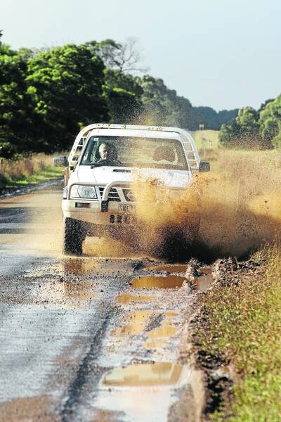 A driver tries to traverse the crumbling Macarthur-Penshurst Road. 110607DW02 Picture:: DAMIAN WHITE
