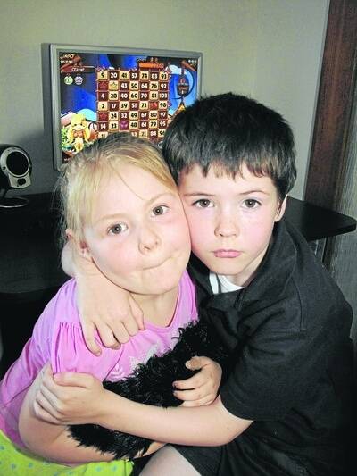 Matthew Houtsma hugs his sister Michiela.  A specially-trained dog may help his autism.091113EH09