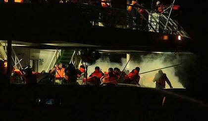 Passengers on the second deck of the Mavi Marmara run as they are surrounded by smoke from the tear gas . Photo: Kate Geraghty