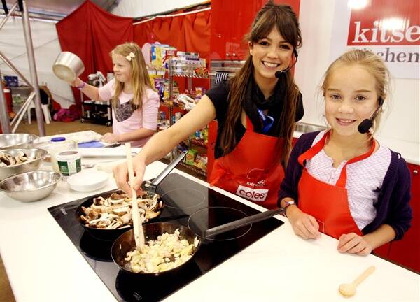 Warrnambool’s Belle Williams (left) lends a hand to former Masterchef contestant Fiona Inglis and Junior Masterchef contestant Siena Johnston, 10, at the Fun4Kids Festival yesterday.