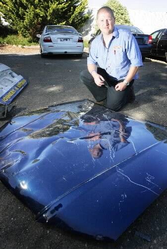 Warrnambool panel shop operator Scott Cooper with the 'roo-dented bonnet of a car. Damage caused by collisions with wildlife can cost up to $6000 to repair, he said.090422AM49 Picture: ANGELA MILNE