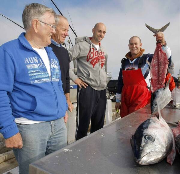 Ocean swimmer Baylee Rogers (left), Cr Rob Askew and fishermen Lucas Wilson and Leigh Anderson (holding a tuna) want bins installed at Warrnambool’s boat ramp to prevent unwanted fish parts being dumped in Lady Bay and attracting sharks. 