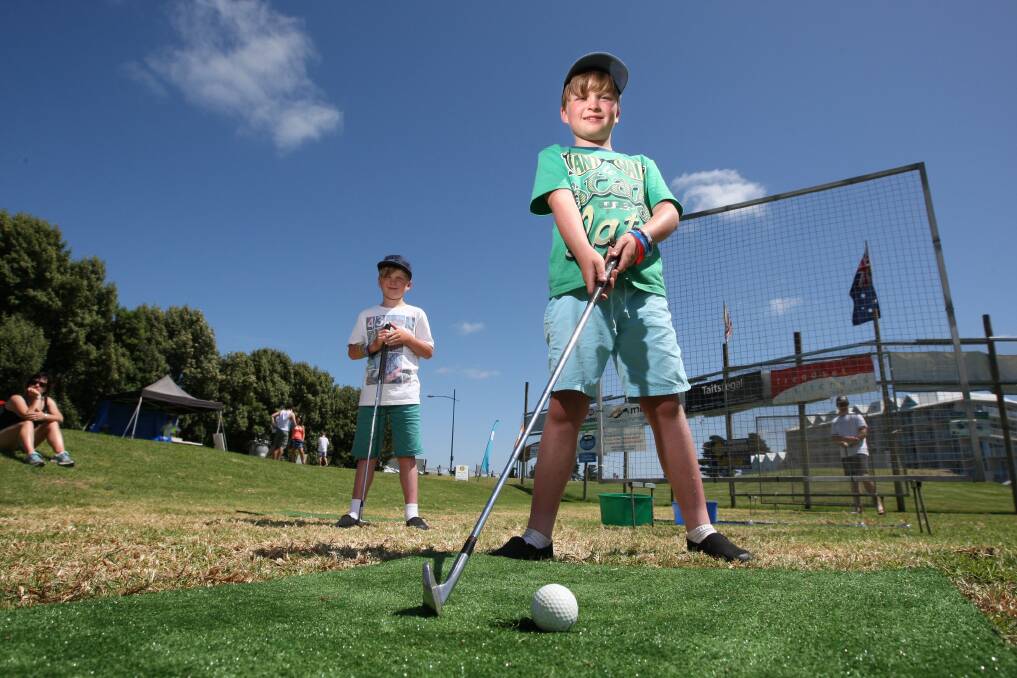 Eight-year-old Hamilton twins Chester (left) and Clancy Wilder try their luck at the Rotary hole-in-one competition. 