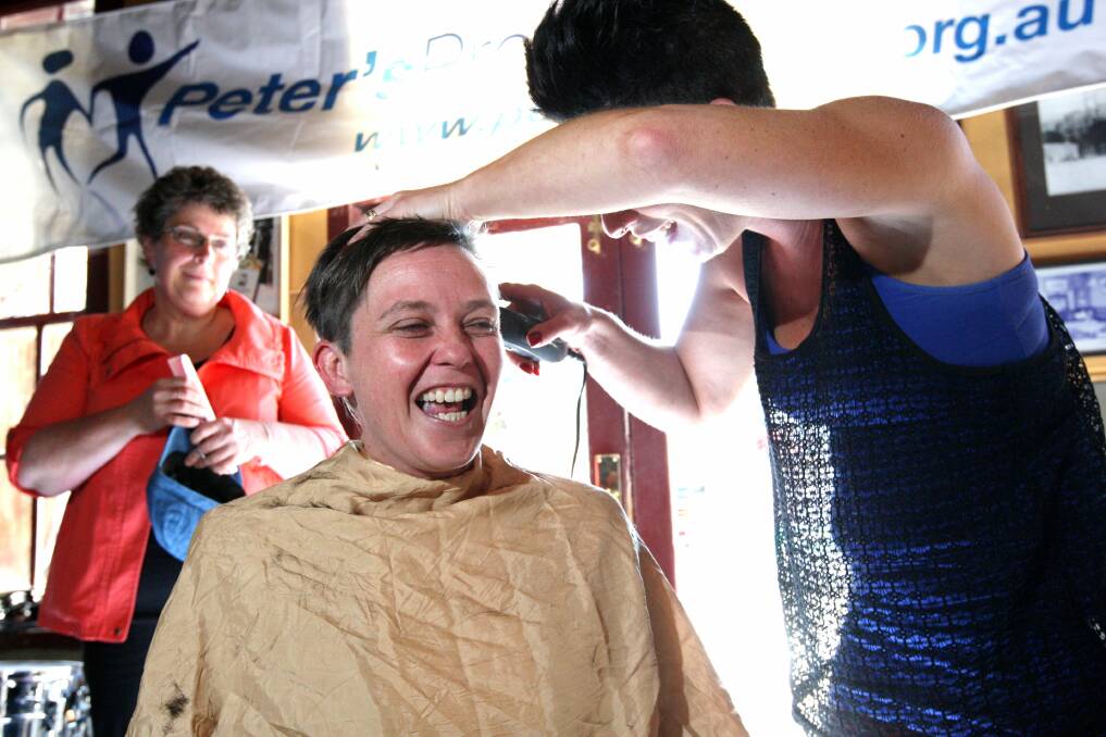 Oncologist Terri Hayes prepares to lose her locks as she submits to Nadine Wheatley’s clippers in the name of fund-raising for Peter’s Project at the Hotel Warrnambool yesterday.  