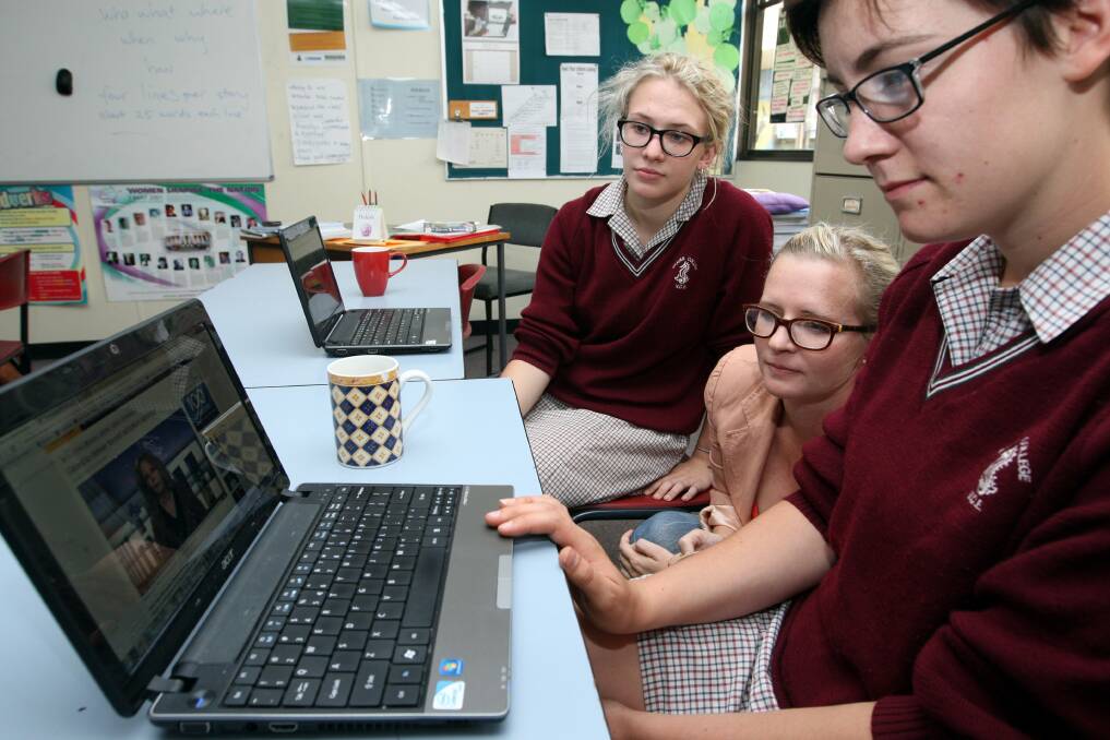 Brauer College students Lani Sprague, 15, (left) and Kate Harrison, 16, (right) watch live coverage of Prime Minister Julia Gillard’s national apology on forced adoption with Deakin University journalism lecturer Kristy Hess. 