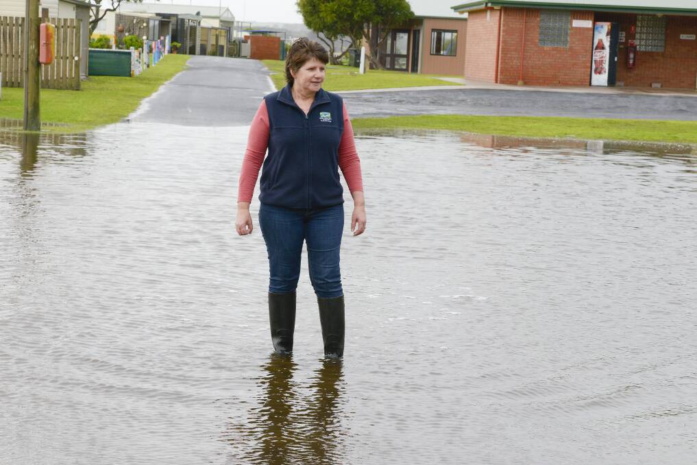 Relief caretaker at the Peterborough caravan park, Wendy Kerr, wades through  the rising waters