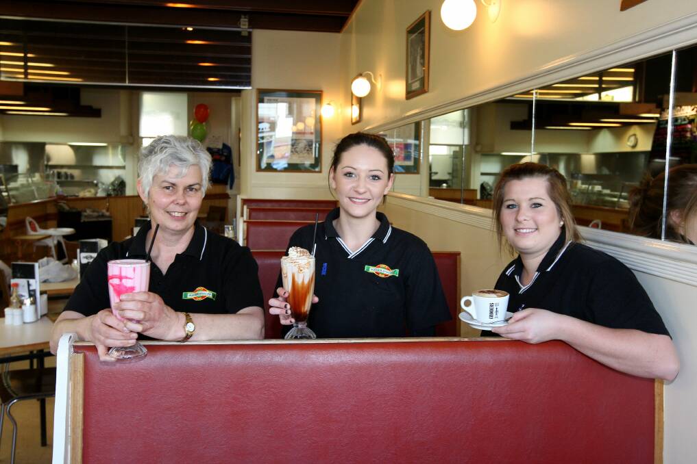Staff (from left) Diane Coates, Kasey Jarvis and Ebony Mackay toast the good health of their cafe, Warrnambool’s Mack’s Snacks, which has been operating for 65 years.