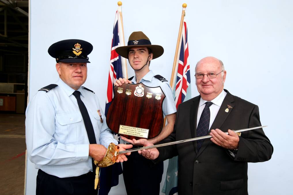 Commanding officer Paul Marsland (left) receives the sword that was gifted to the Warrnambool Air Force Cadets from Warrnambool RSL president John Miles, as cadet of the year Brent McCosh, 18, looks on. 