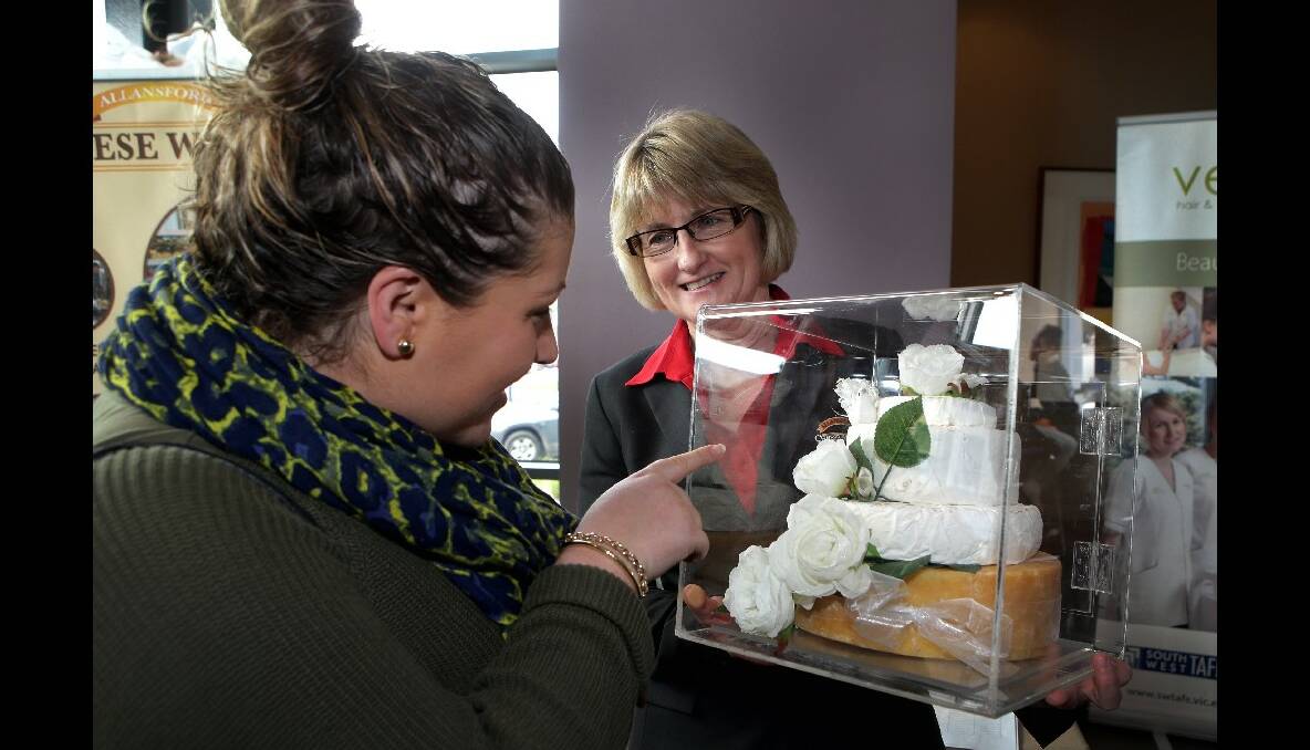 Kim Kavanagh from Cheeseworld shows  Amy Holscher a cheese wheel wedding cake. Picture: LEANNE PICKETT