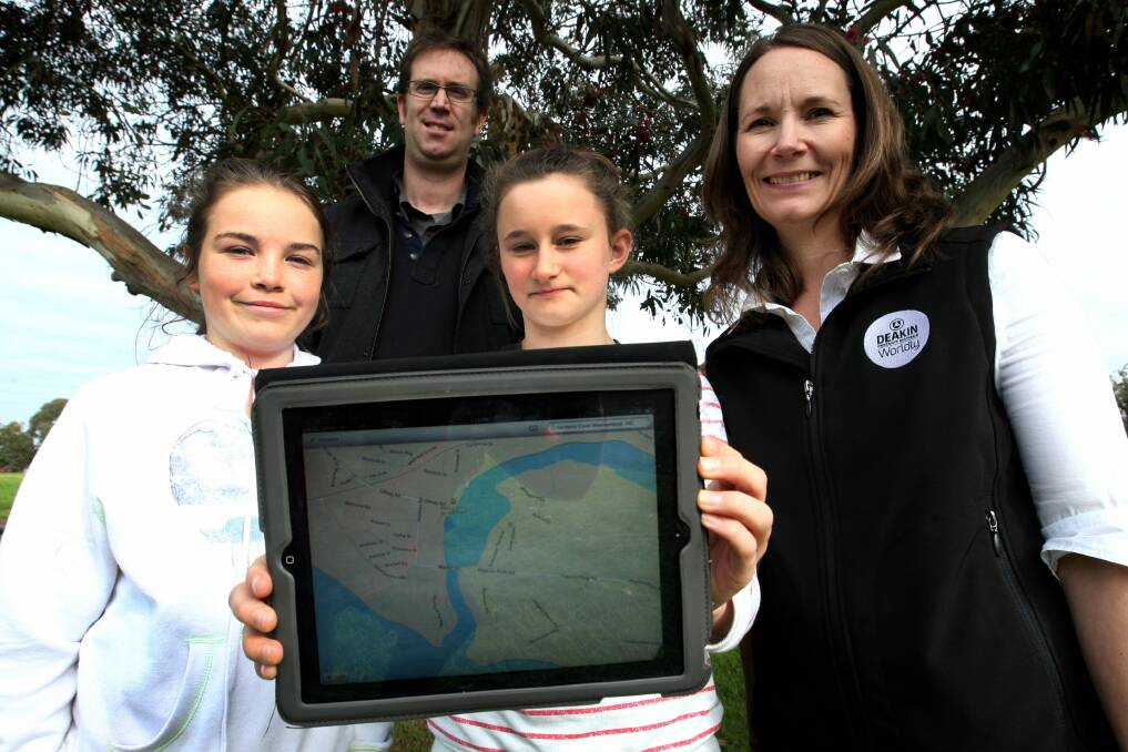 Brauer College students Angelique Johnson (left) and Alicia Byron, both 12, map local sites of indigenous significance on a tablet with the assistance of Brauer teacher Will King and Deakin University lecturer Julianne Lynch. 