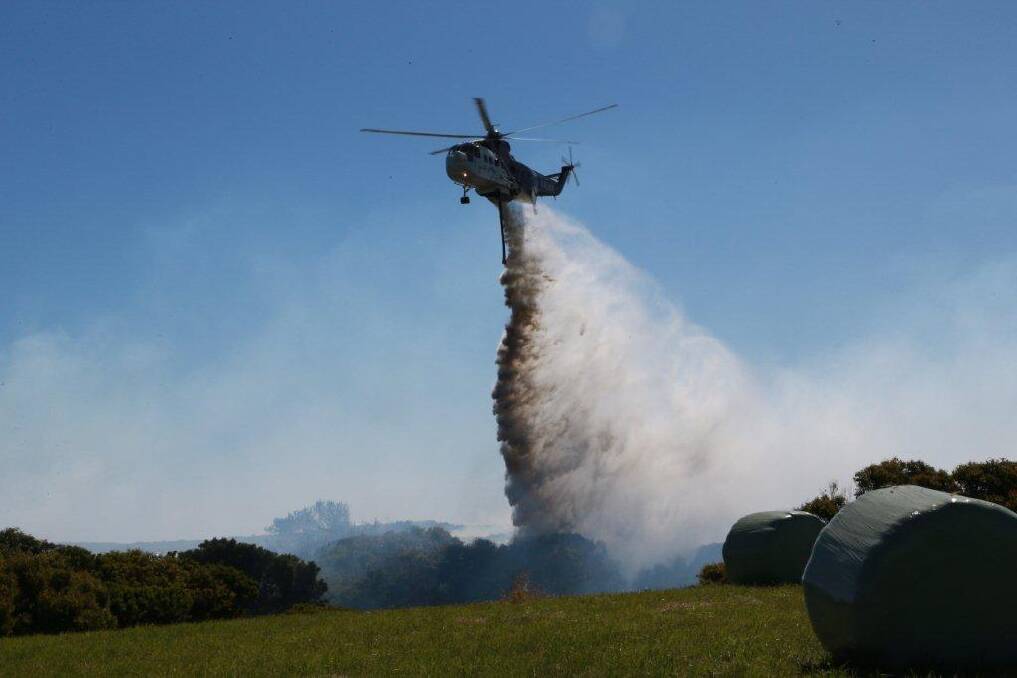 An aerial water assault helps contain the scrub fire near Peterborough.