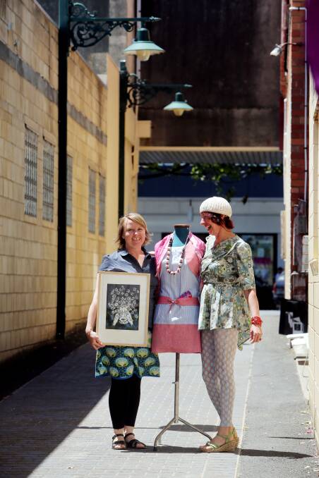 F Project vice-president Megan Nicolson (left) and Sweezy Emporium manager Suzi Walter add a dash of colour to Ozone Walk to help launch the laneway festival.