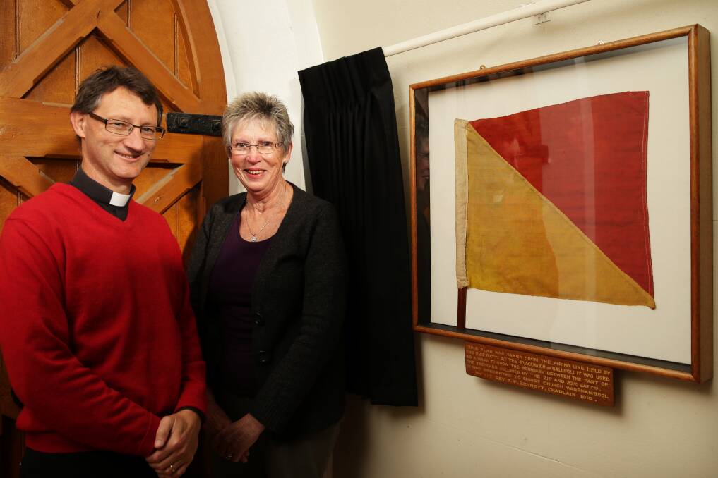 Christ Church's Father Scott Lowery and archive project co-ordinator Judy Miller with the marker flag brought back from Gallipoli by the 22nd Battalion's chaplain, Captain Thomas Bennett.