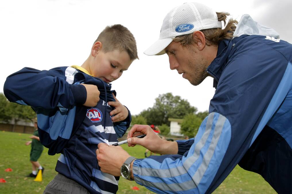 Local export Billie Smedts signs 11-year-old Charlie Blacker’s Geelong jumper at Allansford. 