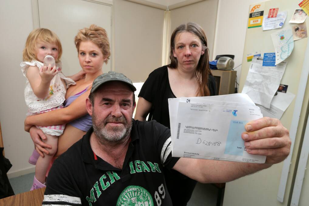 Warrnambool’s Greg Fulton, with his wife Debbi and daughter Miranda, holding her daughter Emily, displays a Telstra bill dated December 2.  