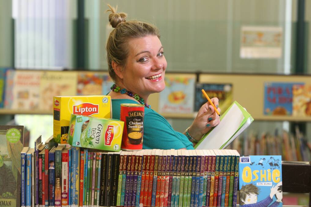 Warrnambool library officer Jane McDonald tallies up the unpaid fines for overdue items. 