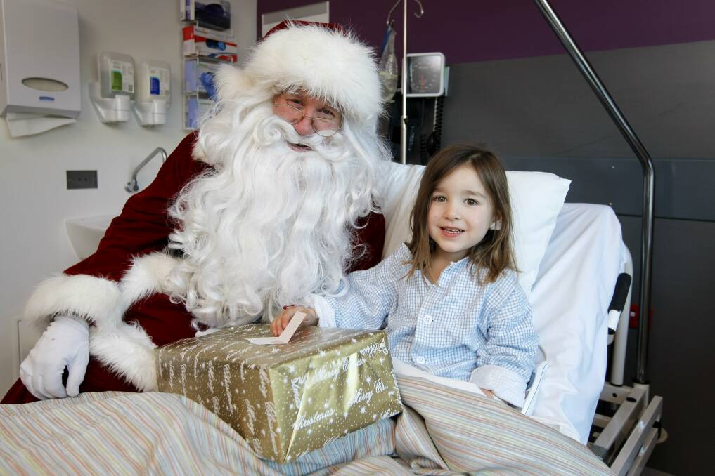 Aurora Logan, 3, receives her Christmas gift from Santa. 