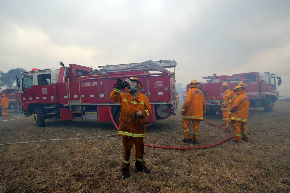 A Sunbury firefighter quenches his thirst after battling to stop embers from reaching farm land outside the Lower Glenelg National Park at Drik Drik.  