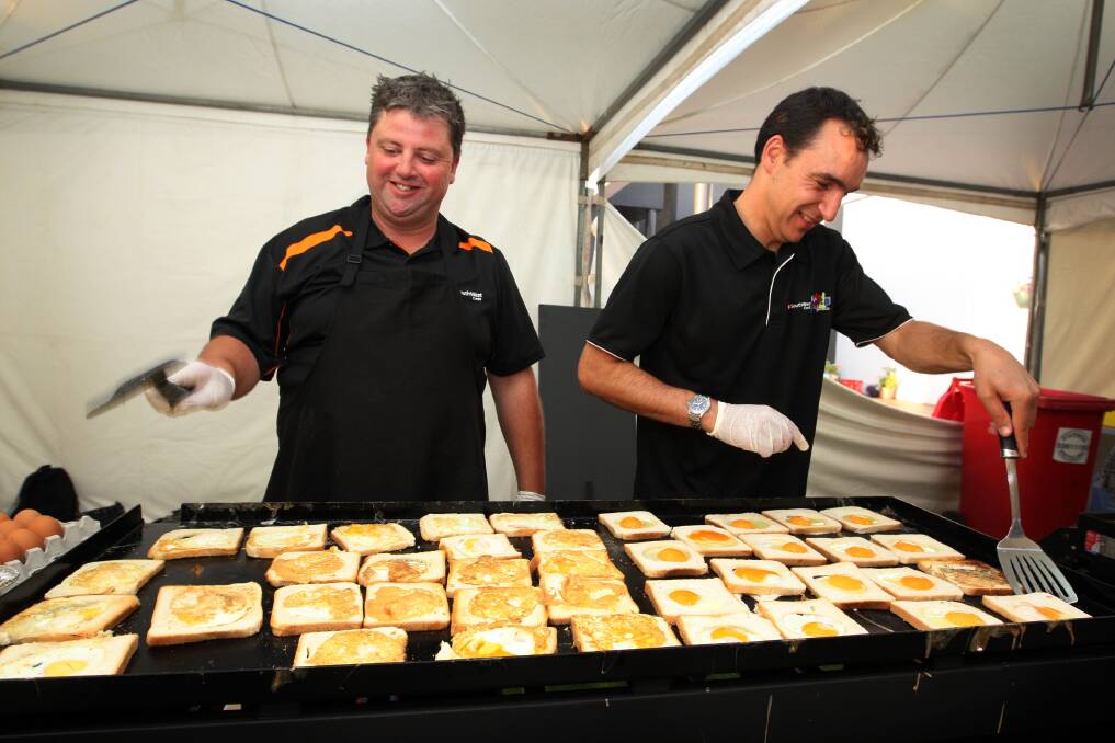 Volunteers Shane Watts and Gavan Cooper cater to the hungry breakfast crowds.