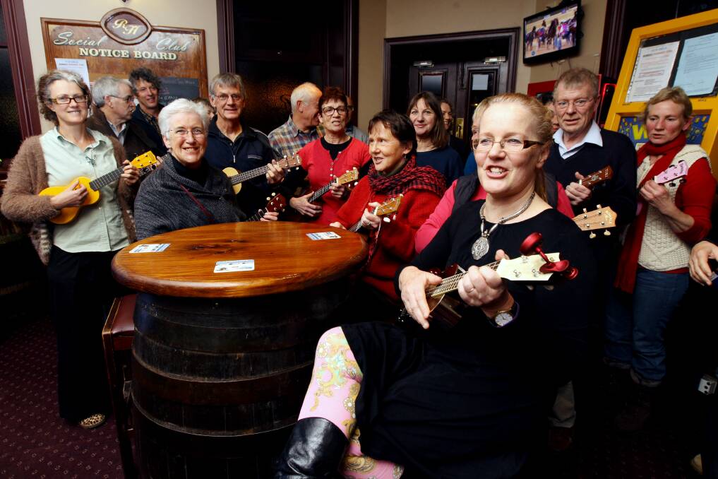 Annie Carmichael (foreground) leads members of the fast-growing Warrnambool Ukulele Group in a practice session at the Royal Hotel.