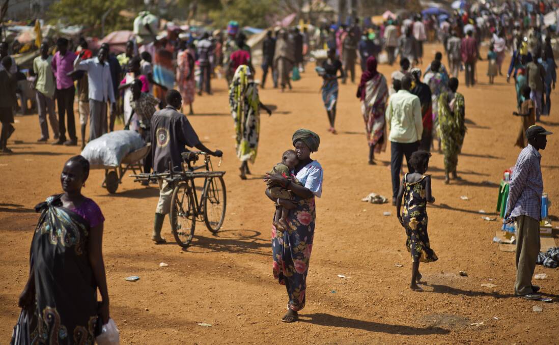  Displaced people walk inside a United Nations compound which has become home to thousands of people displaced by the recent fighting, in Juba, South Sudan